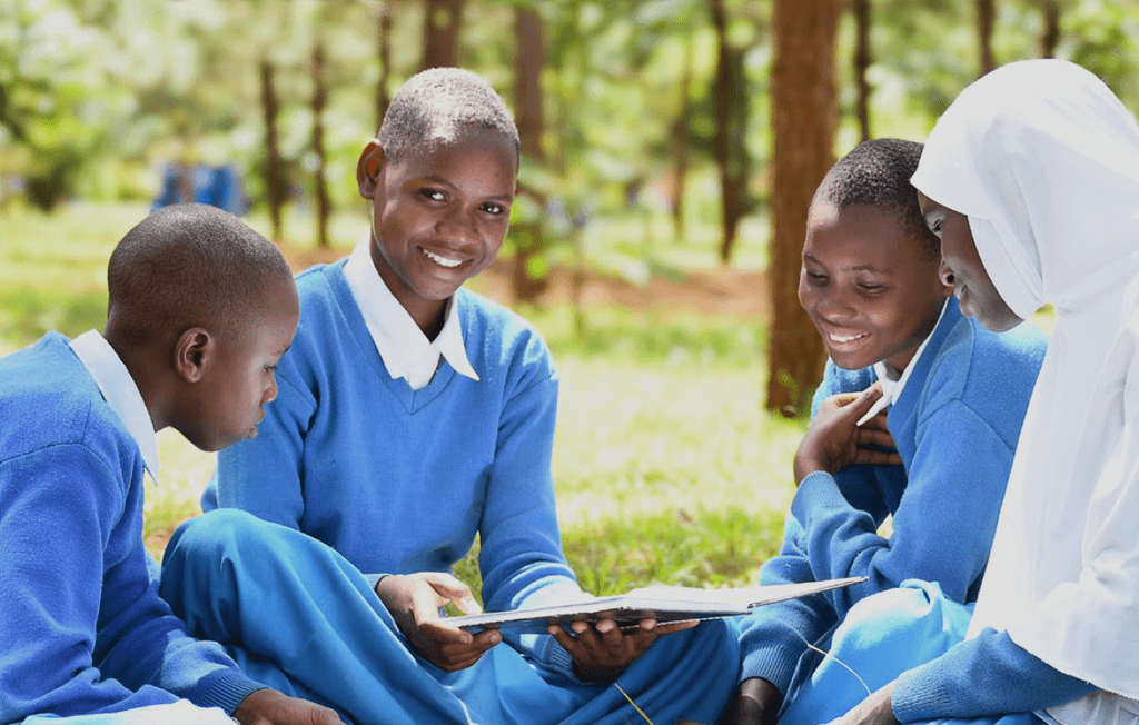 Children in school uniform reading a book